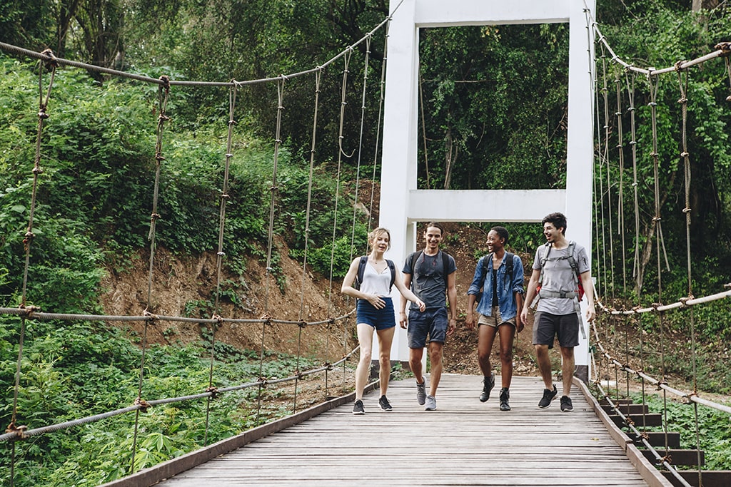 group-friends-walking-bridge-tropical-countryside-adventure-journey-concept-min