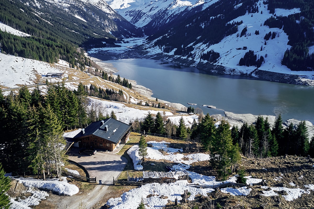 high-angle-shot-mountains-river-with-isolated-house-forest-shore-min