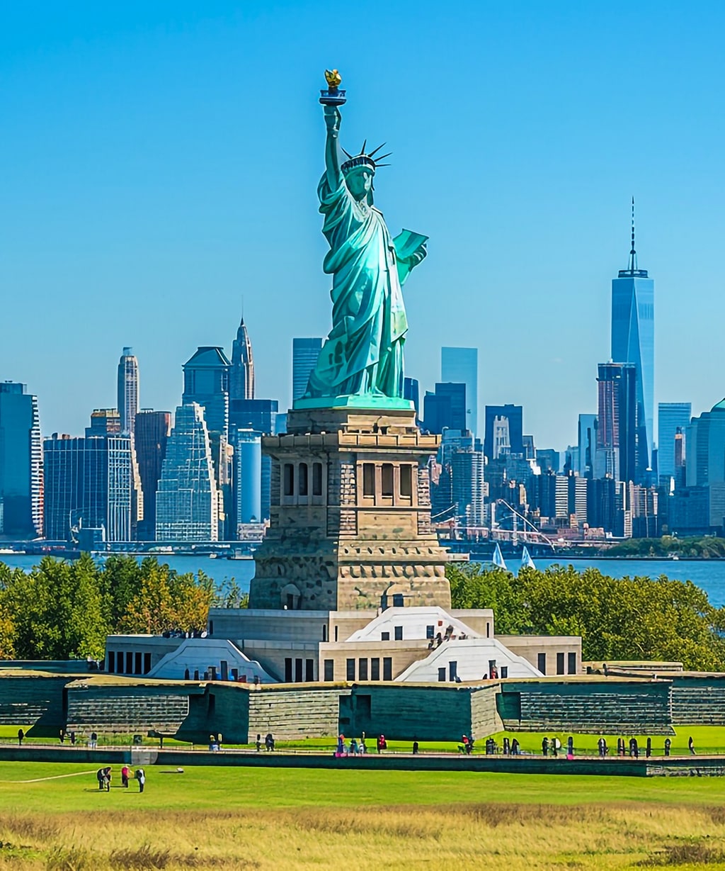 statue-liberty-stands-front-city-skyline-min