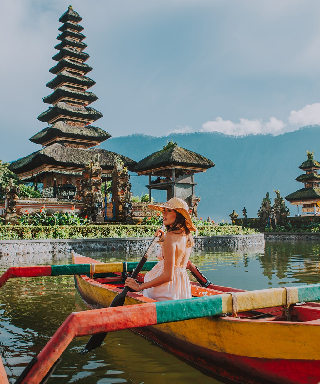woman-outrigger-pura-ulu-danau-temple-against-sky-min